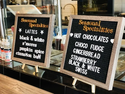 Two felt letterboards listing seasonal lattes and hot chocolates