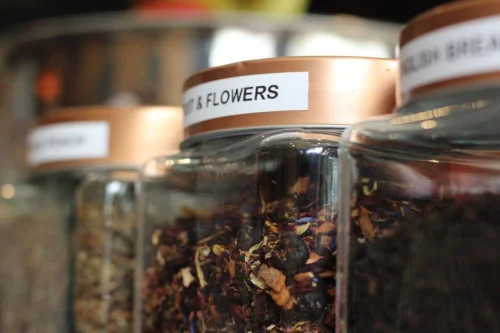 A glass jar of loose-leaf tea on the shelf