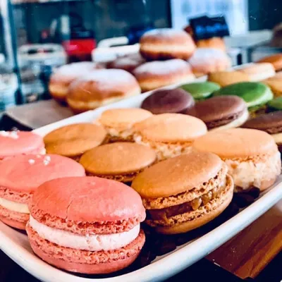 A tray of macarons in pink, orange, green and brown